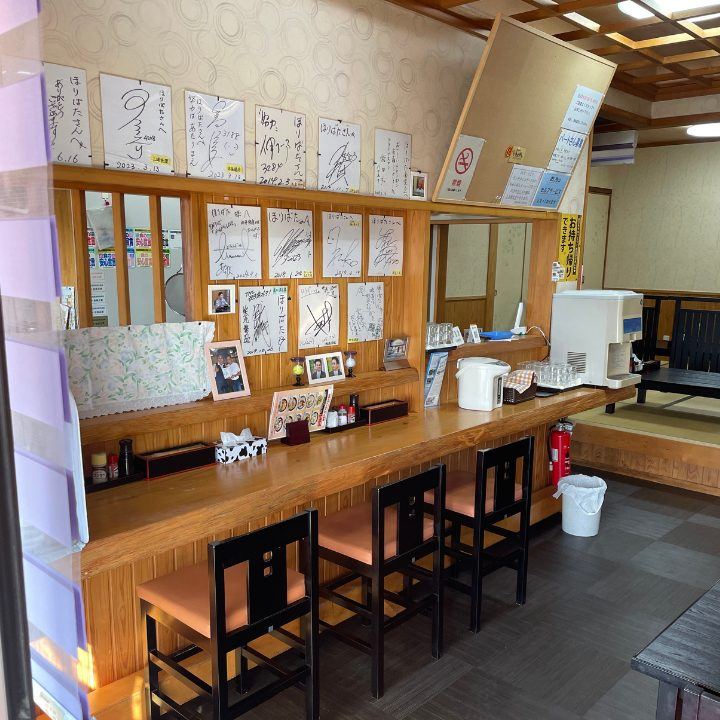 ほりばたのカウンター席と、壁一面の色紙
